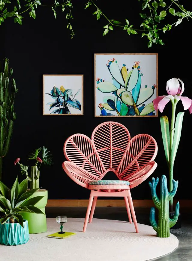 mobilier retro et plantes intérieur chaise fauteuil rotin en forme de fleur rose mur noir contraste et plantes tropicales