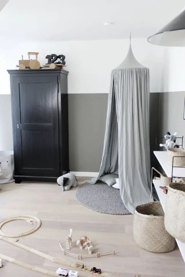 deco chambre enfant ciel de lit exemple espace jeu tapis rond gris parquet bois clair mur gris et blanc soubassement armoire parisienne foncée ambiance neutre et douce