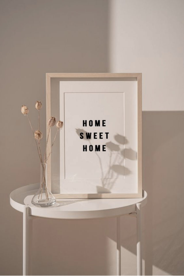 slow deco cadres affiches exemple mise en scene posé sur un guéridon tabouret encadrement bois phrase home sweet home jolie typo