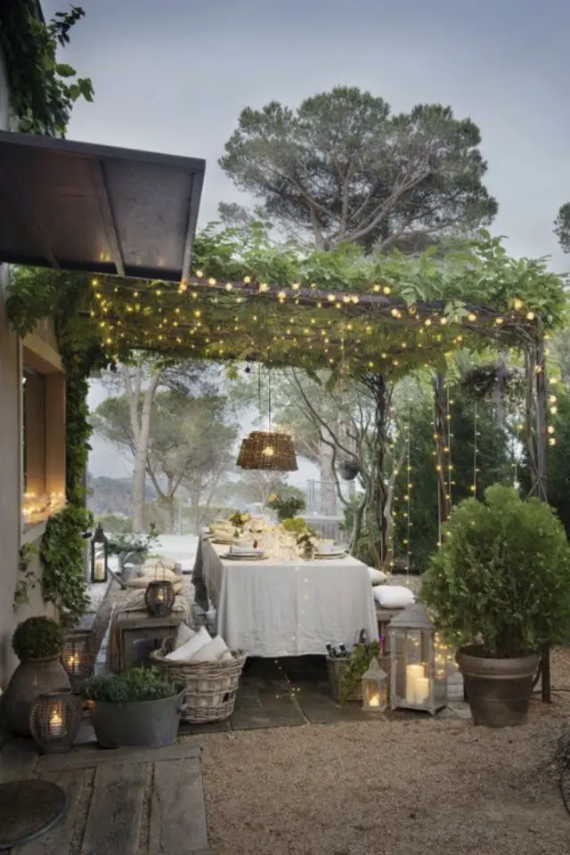 repas en exterieur grande table familiale pergola guirlande lumineuse inspiration nappe élégante