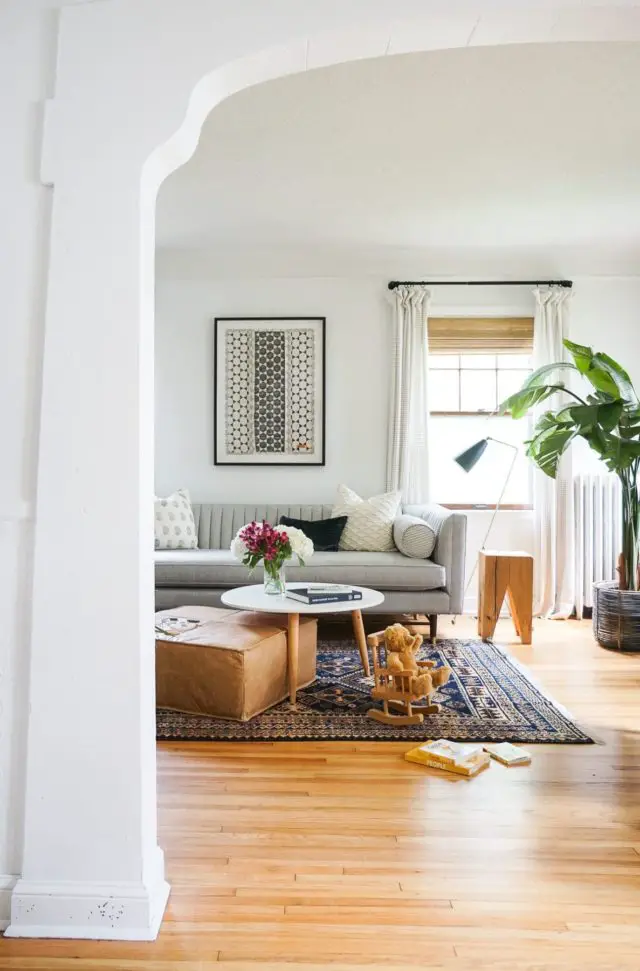 slow deco salon familial minimaliste exemple canapé gris tapis foncé parquet ambiance douce