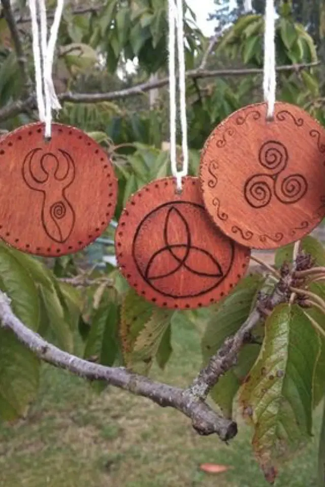 celebration yule solstice hiver decoration sapin cuir gravé symboles