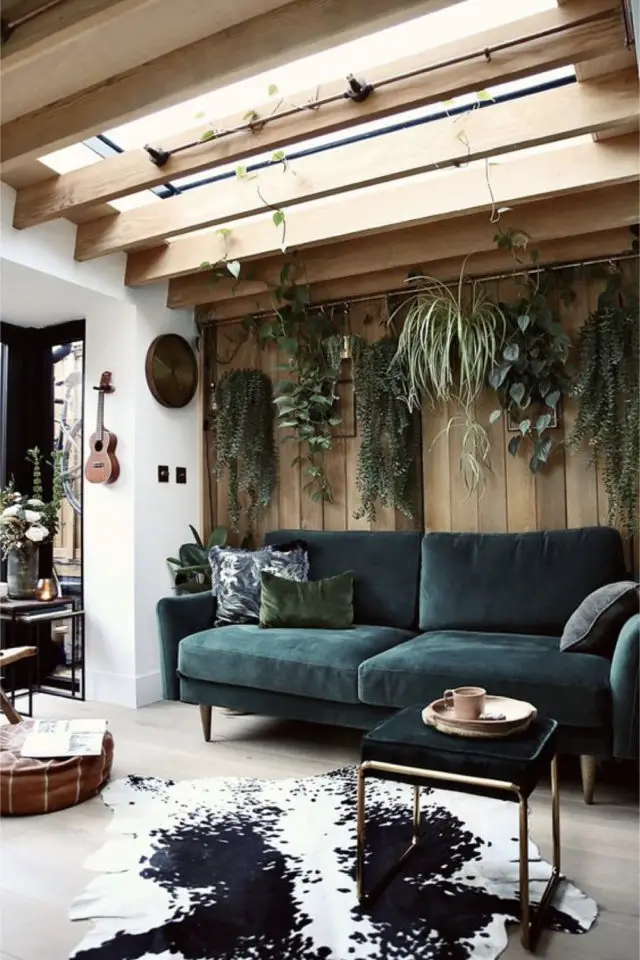 deco interieure biophilique exemple salon séjour moderne canapé velours vert plantes suspendues plafond bois