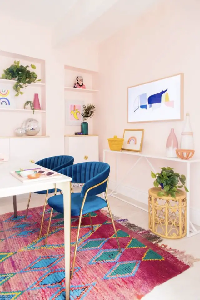 salle a manger maximalisme couleur mur rose pâle tapis coloré  fauteuil de table bleu en velours