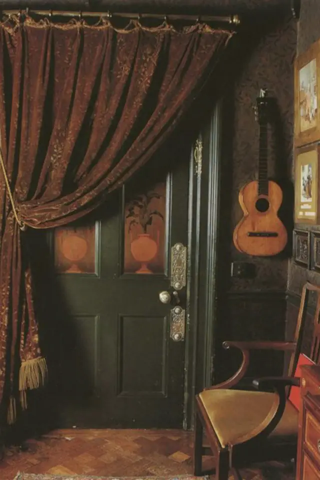 ambiance poetique decalee classique chic décoration entrée porte peinture verte rideaux en velours théêtre rouge petite guitare soubassement