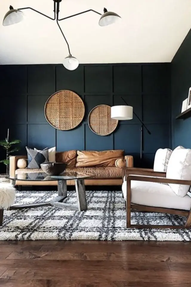 salon masculin fauteuil cuir naturel canapé mur bleu sourd mate décoration murale cannage tapis noir et blanc quadrillé