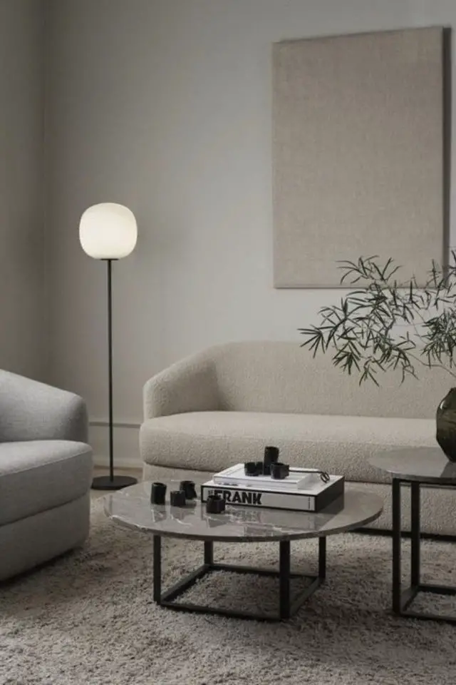 salon style minimal luminaire lampadaire à côté du canapé pied noir métal globe blanc rond intérieur simple neutre beige