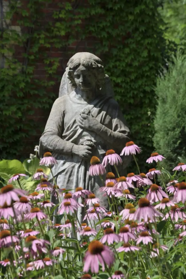 ambiance jardin poetique exemple statue enfant ange ancien gris fleurs roses massif 