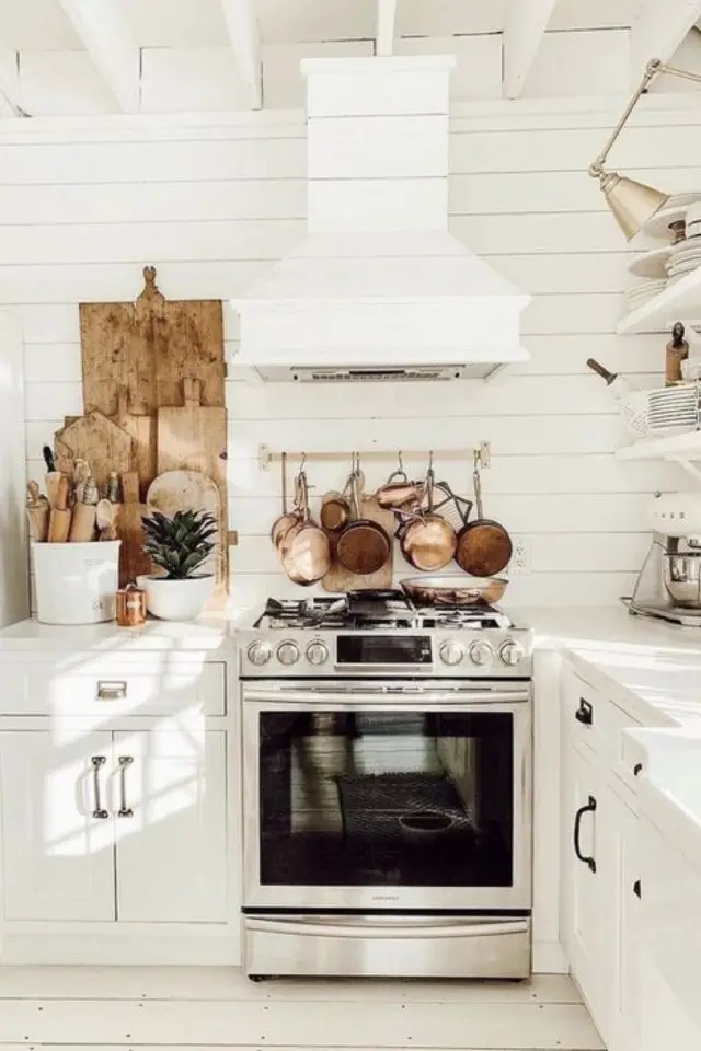 exemple decor cuisine traditionnelle blanc hotte gazinière style piano de cuisson casseroles en cuivre accrochées au mur