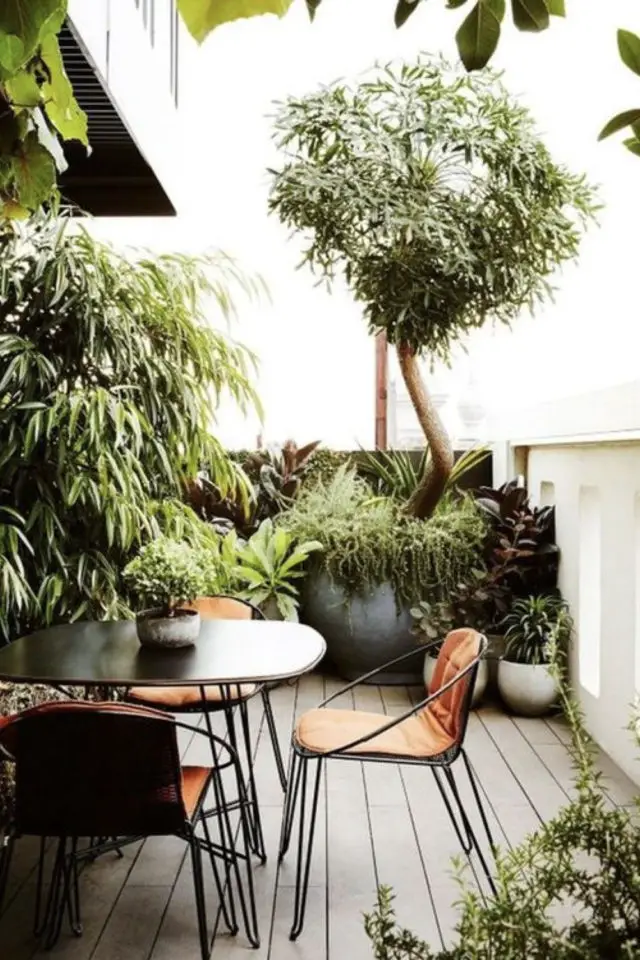 exemple agencement balcon en longueur petite table métal noir plantes vertes arbuste sol  bois