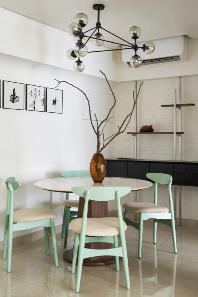 interieur contemporain minimaliste lumineux coin repas table ronde plateau bois clair chaise design épuré vert céladon bibliothèque