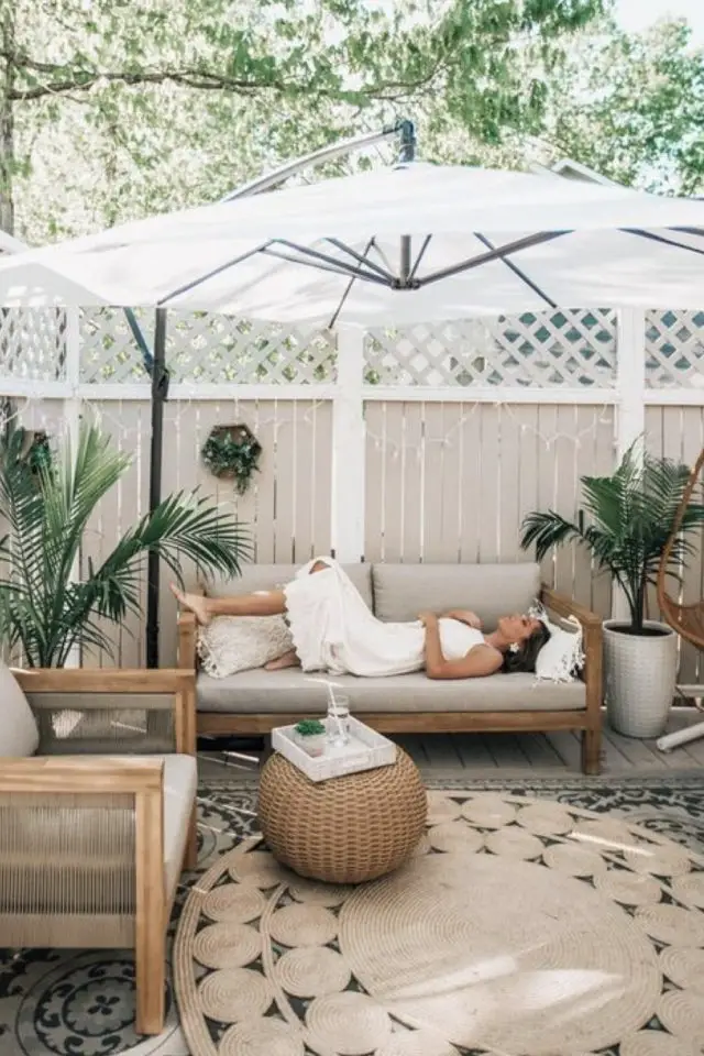 terrasse deco simple et chic exemple grand parasol déporté salon de jardin en bois banquette tapis rond en jute cosy et élégant