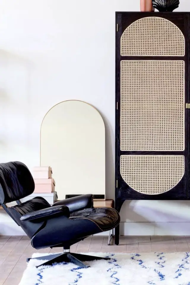 deco design moderne exemple meuble noir avec porte en cannage miroir arrondi sur le haut fauteuil en cuir