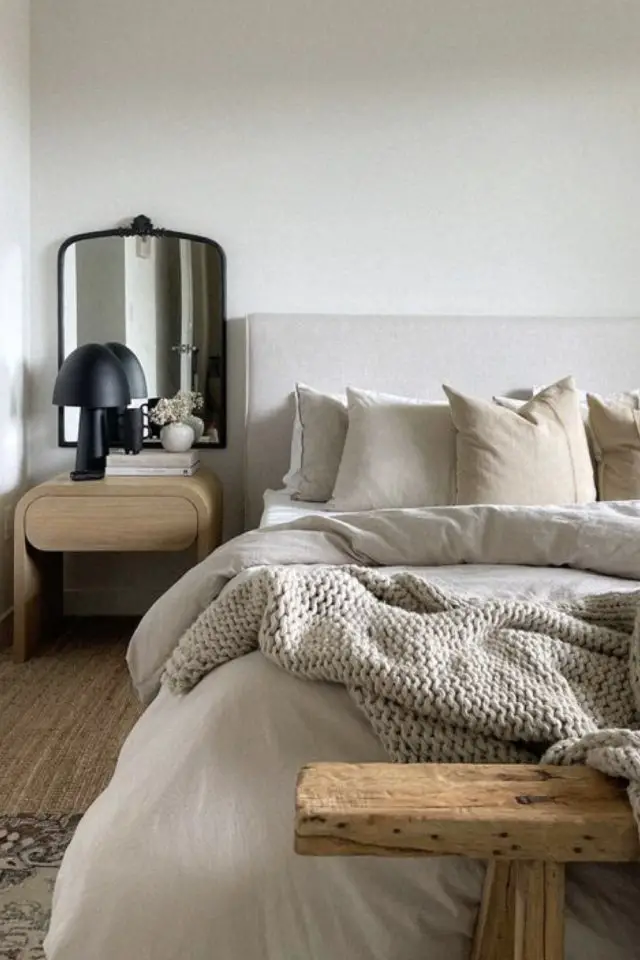 decoration chambre adulte minimale et chaleureuse petite lampe de chevet noir design plaid en laine tricoté grosse maille banc au bout du lit bois descente de lit en jute