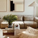 interieur minimal et chaleureux exemple salon séjour canapé fauteuil couleur neutre tableaux abstrait luminaire tapis simplicité épuré