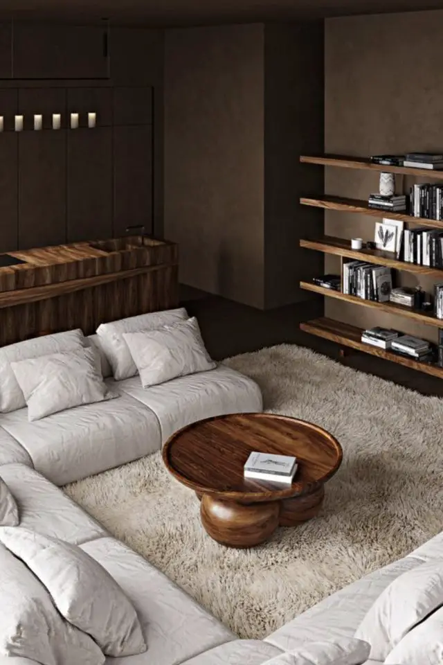 salon minimaliste cosy exemple canapé d'angle moderne beige épuré tapis moelleux table basse en bois sombre noyer  ronde design mur peinture marron chocolat étagère bibliothèque