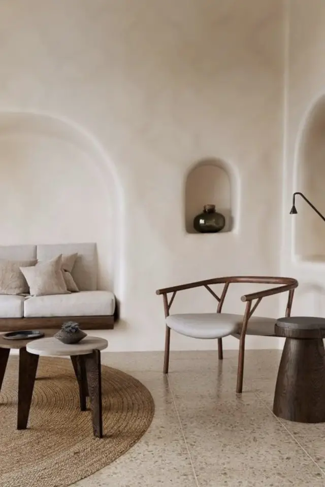 salon minimaliste cosy exemple niche arche tendance banquette couleur gris neutre clair fauteuil design en bois bout de canapé rond