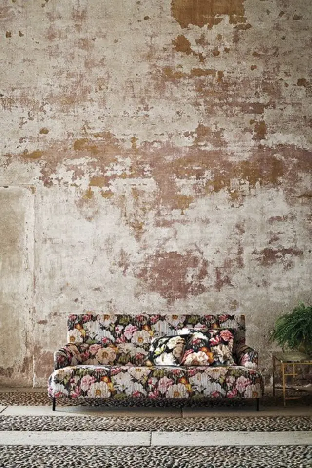exemple tendance deco trash wall enduit usé décrépi mur à l'arrière contraste canapé.à fleur salon