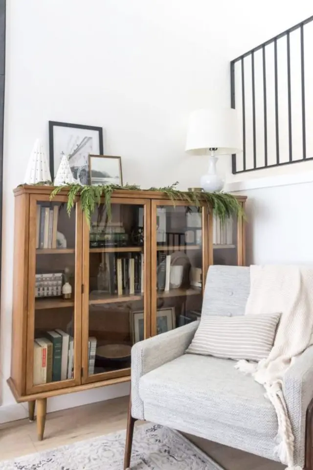 meubler angle salon fauteuil cosy gris clair classique petit coussin et plaid assorti lampe à poser sur bibliothèque en bois coin lecture repos