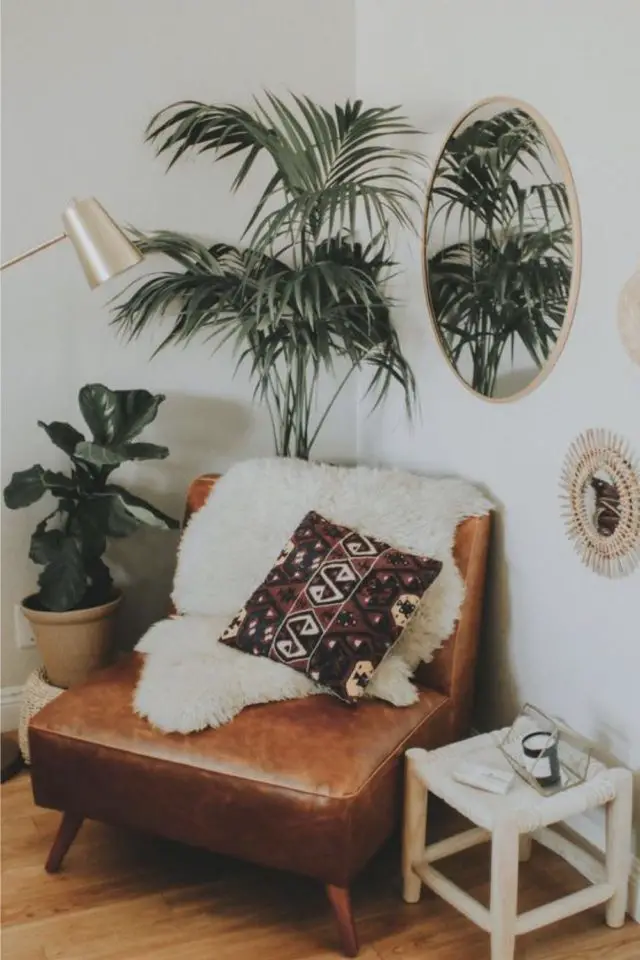meubler angle salon fauteuil cosy vintage en cuir plaid en fausse fourrure blanche coussin plante verte petit tabouret bout de canapé