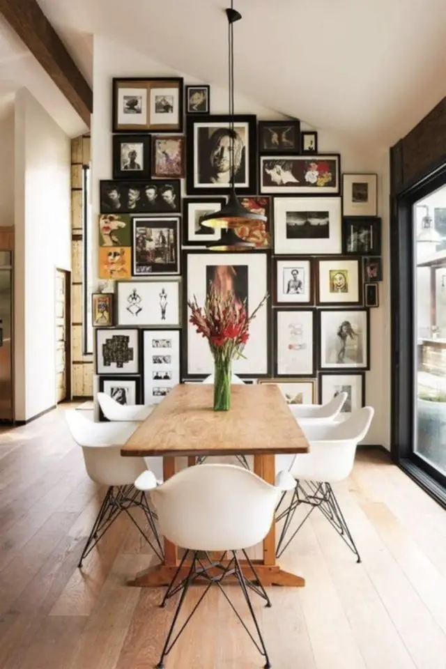salle a manger style eclectique espace en longueur mur accent avec patchwork de cadre et affiche table en bois fauteuil eames blanc