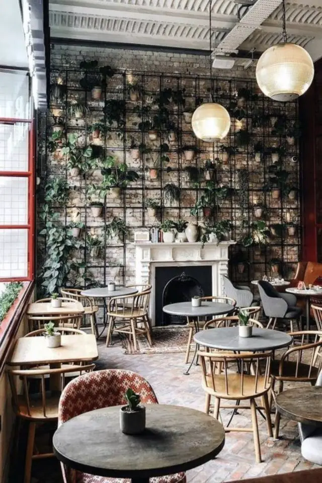 salon de the decor vegetal mur plantes vertes accrochées et suspendues petite table ronde en bois