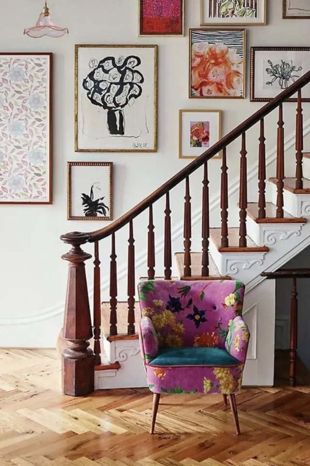 deco entree style eclectique vintage fauteuil tissu à fleur coloré cage d'escaliers cadres poster maximalisme