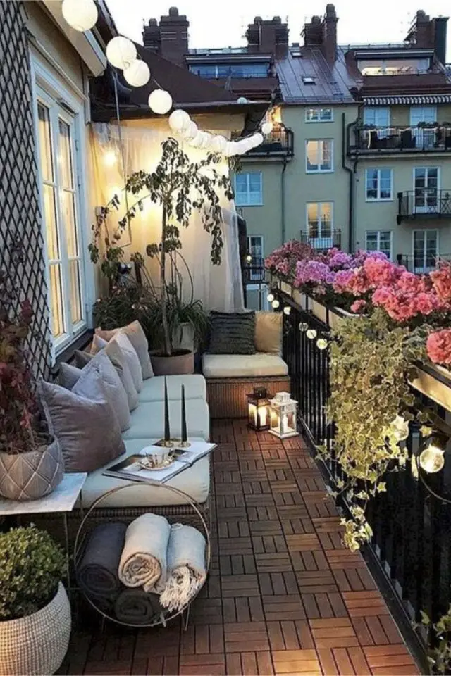 decorer balcon avec style banquette coussin guirlande lumineuse guinguette fleur rose en jardinière déco garde-corps