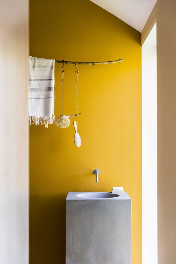 salle de bain mur jaune lave main beton