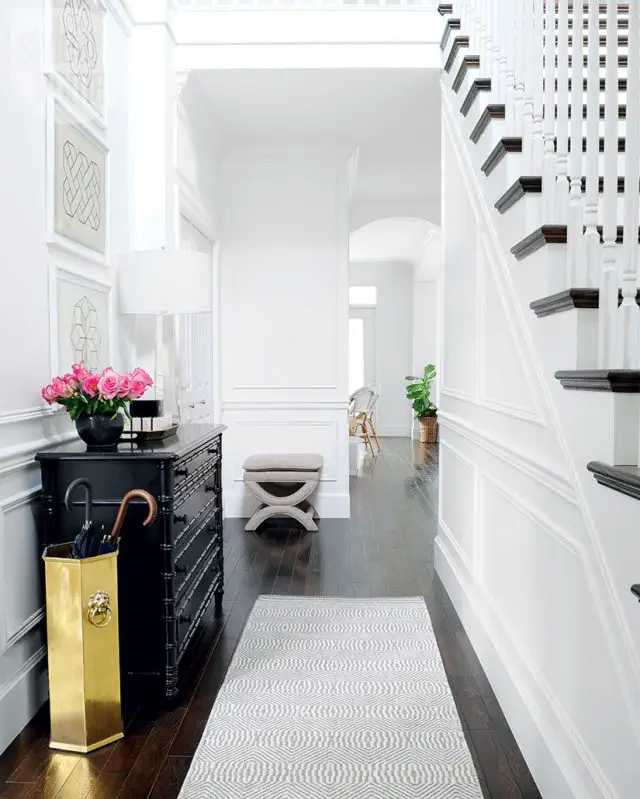 deco entree elegante feminine lumineuse sol foncé escaliers blanc meuble noir 