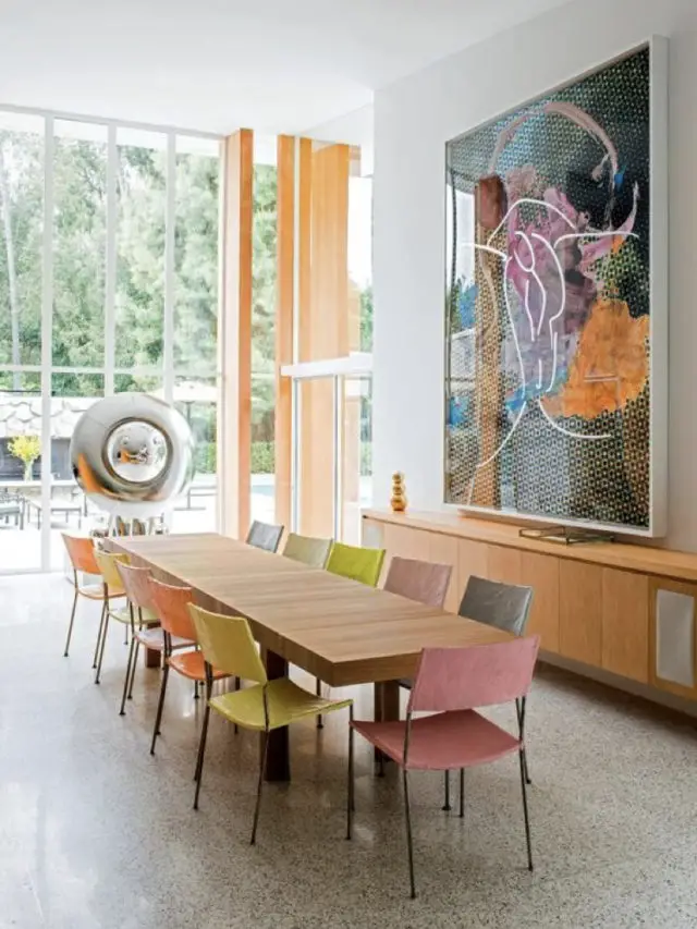 style arty decoration salle a manger chaises colorées dépaeillées grand tableau au dessus enfilade