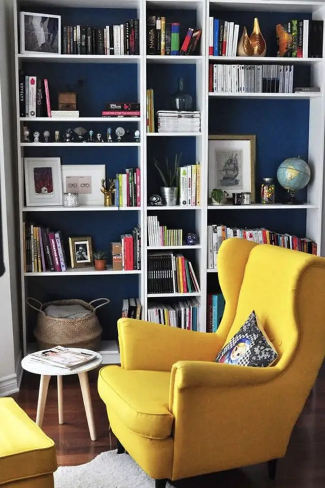 exemple amenagement coin lecture salon bibliothèque blanche mur peinture bleu canard et fauteuil jaune
