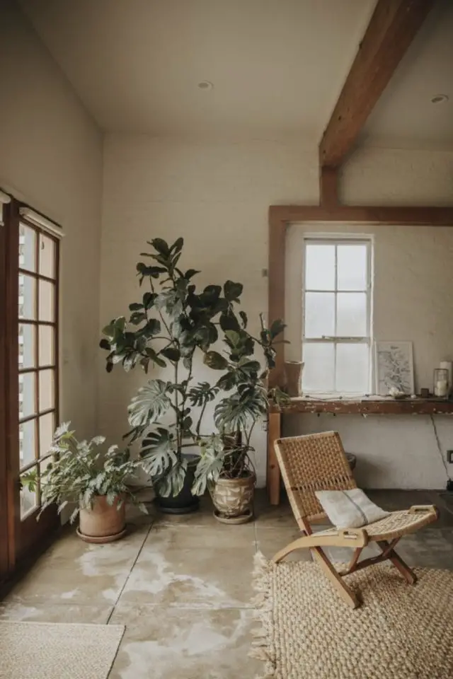 exemple interieur slow deco sol en pierre naturelle fauteuil en bois et plantes vertes 