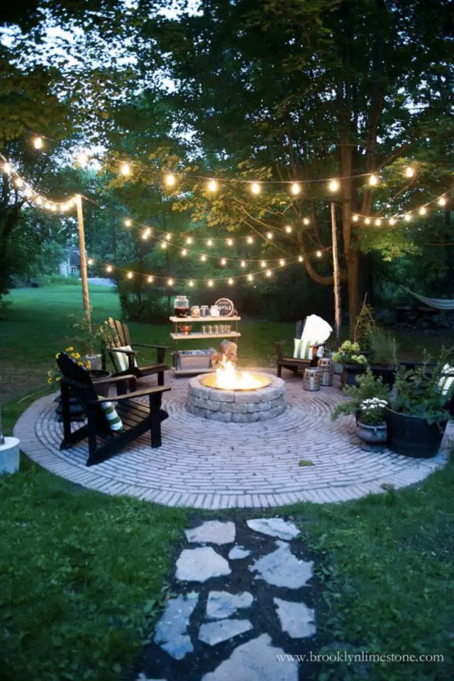 brasero exemple amenagement jardin terrasse en cercle en pavé guirlande extérieure lumineuse transat convivialité