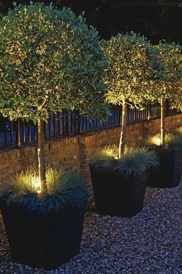 eclairage jardin exemple a copier allée pot de fleur arbustes lumière indirecte ambiance tamisée