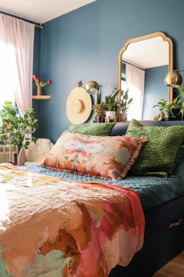 exemple chambre adulte plusieurs couleurs peinture bleu foncé parure lit orange rouge motif coussin vert velours miroir doré laiton