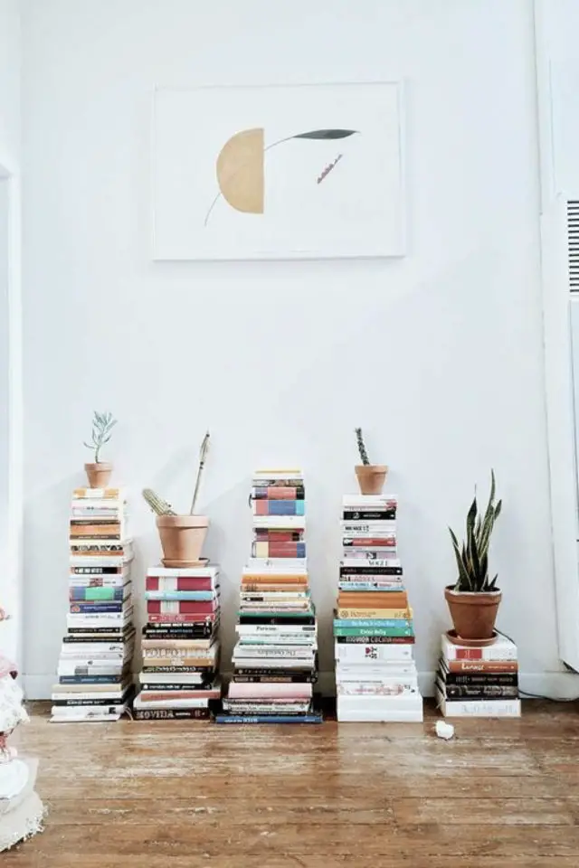 rangement livre piles minimalisme petites plantes couloir mur blanc