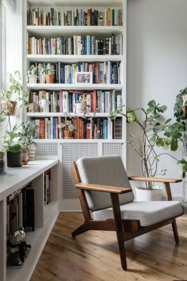 se sentir bien chez soi piece lecture espace lumineux grande fenêtre plantes vertes fauteuil rétro bibliothèque blanche