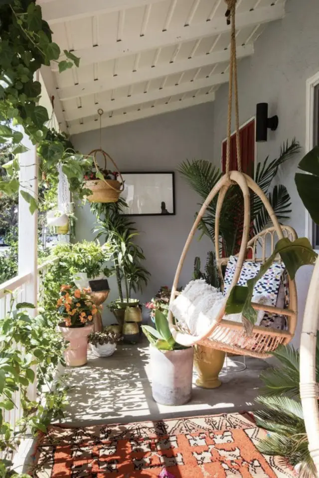 soigner detail deco balcon fauteuil suspendu en rotin plantes vertes suspendues posées en pot moderne