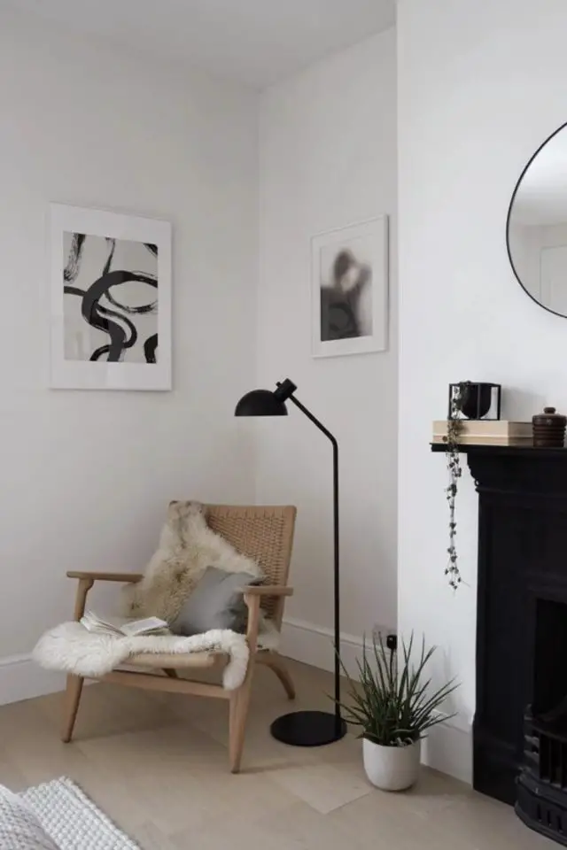 salon minimaliste cosy exemple angle de la pièce fauteuil en rotin plaid en fourrure coussin lampadaire noir design déco murale épurée en noir et blanc