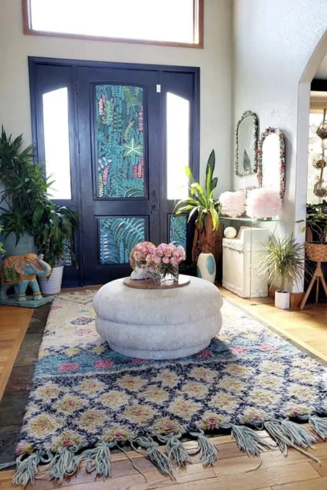 decor eclectique entree exemple grand tapis couleur bleu associé avec la porte peinture papier peint pouf meuble appoint console transparente plante verte
