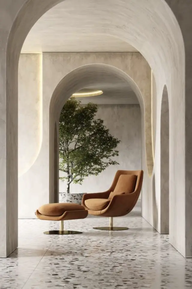 interieur minimaliste tendance deco 2023 béton ciré ciment fauteuil vintage avec repose pied couleur marron