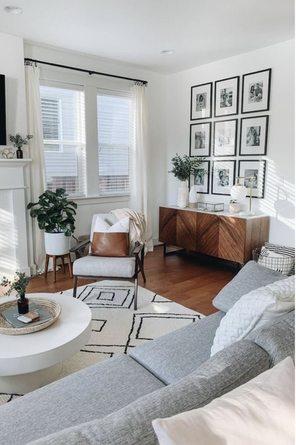 comment reussir deco salon ambiance neutre et chic fauteuil gris tapis noir et blanc enfilade vintage bois cadre photos de famille