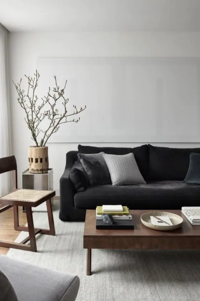 decor salon canape noir ambiance minimale cosy bois blanc plante 