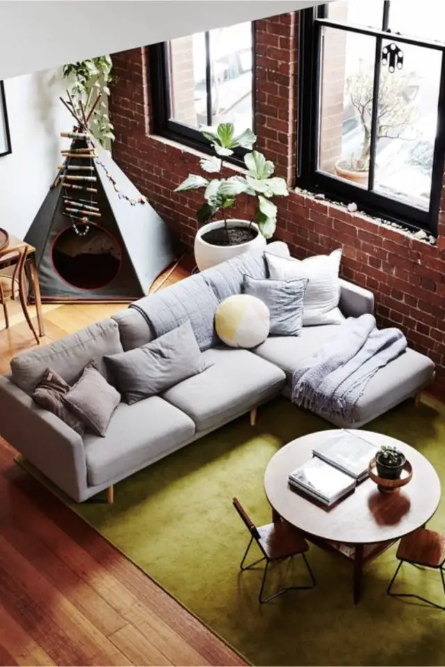 exemple interieur convivial famille grand canapé d'angle gris tapis vert espace jeu enfant salon séjour moderne