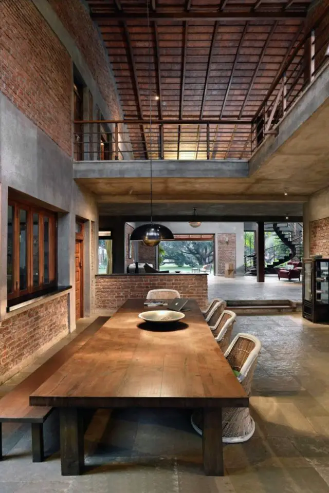 visite maison grand espace ouvert materiaux bruts grande table de salle à manger en bois béton contraste moderne