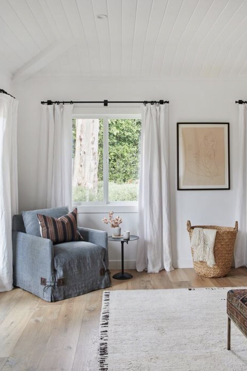 deco chambre parentale tendance grands rideaux blancs jusqu'au sol élégant plafond lambris peint fauteuil panier rotin espace lumineux neutre