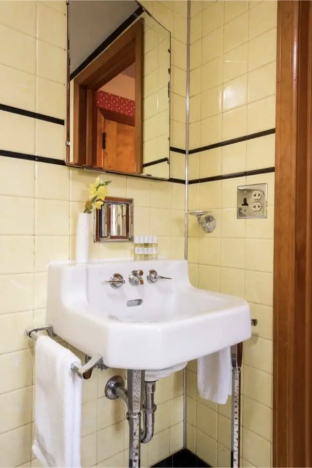 decoration interieur vintage mid century modern salle de bain rétro carrelage jaune pastel frise noire lavabo blanc