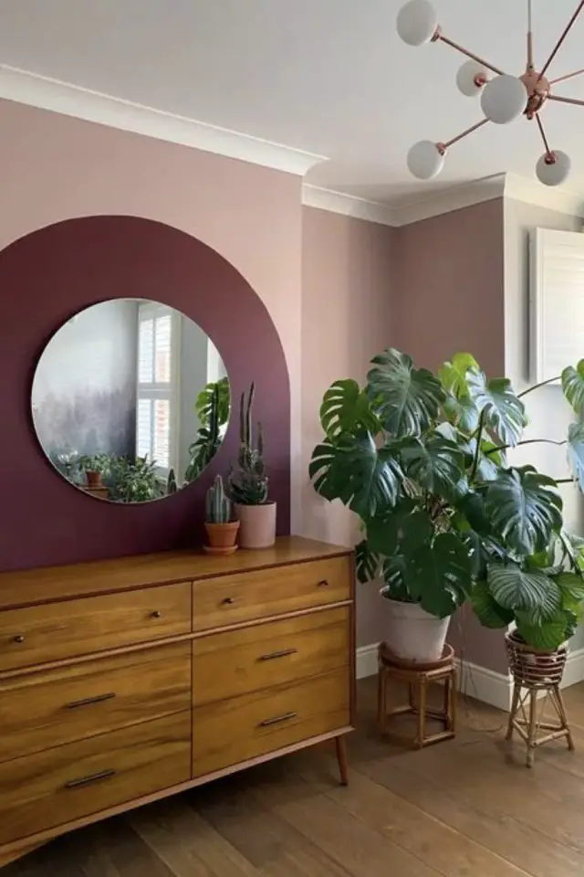 interieur couleur prune exemple décor mur salon séjour moderne peinture arche rose poudré miroir rond meuble enfilade mid century modern plantes vertes