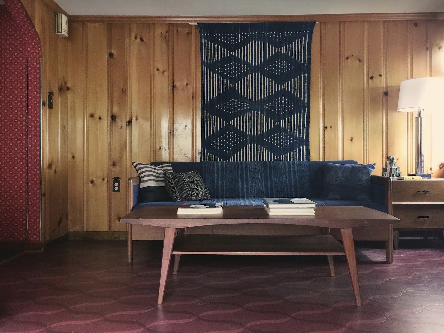 visite deco appartement mid century modern Etats-Unis années 50 lambris bois meuble sombre design minimaliste chaleureux couleur bleu sourd linoléum bordeaux revêtement de sol